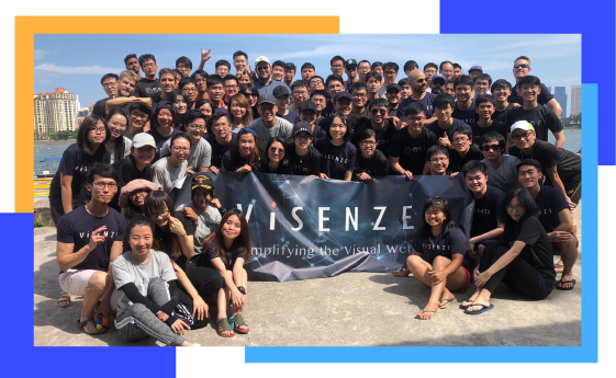 Group photo of ViSenze employees on the beach holding a ViSenze banner