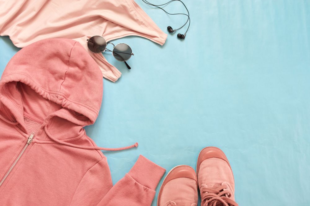 Pink athletic wear and accessories on a blue background.